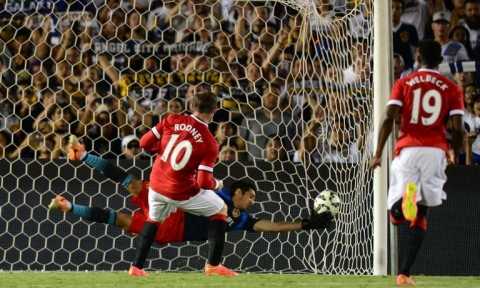 Manchester United's Wayne Rooney scores from the penalty spot as LA Galaxy goalkeeper Brian Perak attempts a save during their in Pasadena, California on July 23, 2014 (AFP Photo/Frederic J Brown)