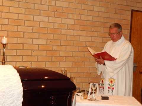 Father James Ralston blessing late Mr. Willie Nsanda's coffin - Photo Credit Nicky Shabolyo