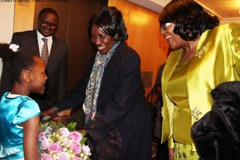 Zambia Vice-President Her Honour Mrs Inonge Wina (second right) receives a bouquet of flowers from eight-year-old Tasheni Bota on arrival at New York Palace Hotel in New York on Sunday, March 8, 2015. Looking on is Zambia’s Ambassador to the UN Her Excellency Dr Mwaba Kasese-Bota (right) and Zambia’s Ambassador to the US His Excellency Mr. Palan Mulonda. The Vice-President is leading the Zambian delegation to the 59th Session of the Commission on the Status of Women. PHOTO | CHIBAULA D. SILWAMBA | ZAMBIA UN MISSION