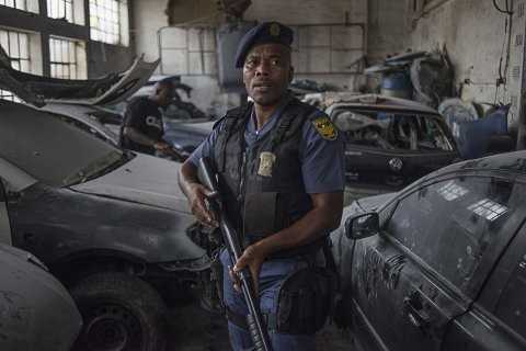A police officer protects the property of foreign nationals in the Jeppestown area of Johannesburg(Mujahid Safodien:AFP)