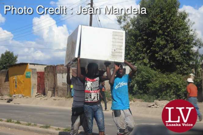 Some guys spotted along Matero- Lilanda carrying a fridge believed to have been looted. . - Lusakavoice.com