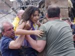 A child is pulled from the rubble of the Plaza Towers Elementary School in Moore, Okla