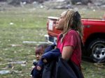 A woman carries an injured child to a triage center near the Plaza Towers Elementary School – AP