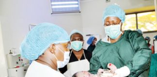 Taking charge of a life- First Lady Christine Kaseba (right) holds a baby after helping in the delivery at Choma General Hospital on Wednesday. – Picture by THOMAS NSAMA