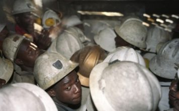 30 employees of Mopani Copper Mines (MCM) are crowded in the elevator, which will bring 1.5 km below the earth to work in the film SOB copper mine. The Swiss commodities company Glencore's Mopani Copper Mines majority shareholder of and employs approximately 20,000 Zambians.