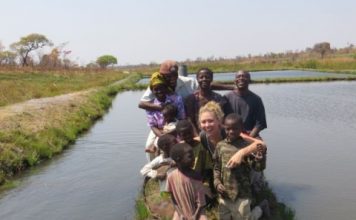 Emily McKeone, a Peace Corps volunteer and University of Nebraska-Lincoln graduate, poses with residents of a rural village in the Luapala province of Zambia. McKeone is raising money to build three wells for three local schools in Zambia.