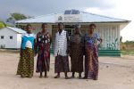 Doris Kangolo (far right) and her maternal grandmother Eunice (second from right) together with caregivers and other pregnant women outside the Fiwale Maternity Waiting House. (@ UNICEF:Christine Nesbitt)