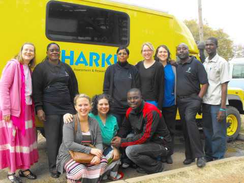 Dr. Jackie Clark (left) and her students — Jennifer Frank (third from right), Joan Oexmann (fourth from right) and Annie Cardella (middle of front row) — worked with Dr. Alfred Mwamba (black-and-red jacket), an audiologist in Zambia, to provide screening tests and train local clinicians
