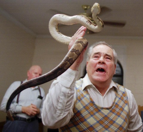 In this Feb. 25, 1995 file photo, Junior McCormick tests his faith by handling a rattlesnake as Homer Browing looks on during services at the Church of the Lord Jesus in Kingston, Ga. Church members believe that if they have faith in God, they will be protected from harm as they handle the serpents. (AP Photo/John Bazemore) In this Feb. 25, 1995 file photo, Junior McCormick tests his faith by handling a rattlesnake as Homer Browing looks on during services at the Church of the Lord Jesus in Kingston, Ga. Church members believe that if they have faith in God, they will be protected from harm as they handle the serpents. (AP Photo/John Bazemore)