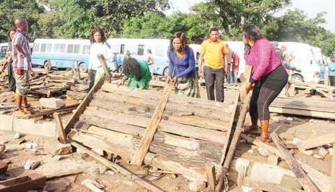KITWE City Council community Police on Thursday removed all wooden stalls mounted on curbs and sidewalks in some parts of the city centre. These vendors were captured picking up debris of their broken stands. – Picture by NKOMBO KACHEMBA.