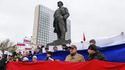 Pro-Russia demonstrators form a Russian flag as they stand under a statue of Soviet revolutionary leader Vladimir Lenin during a rally in Donetsk, Ukraine, Sunday, March 16, 2014. ANDREY BASEVICH, AP
