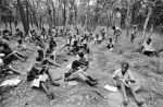 For lack of a school building, the inmates of the Solwezi camp for boys attend lessons in the nearby forest, Zambia, 1979