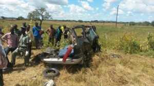 A police officer and onlookers at the scene of the accident in Chisekesi. – Picture by CHAMA MWANSA.  Toyota Noah collided with a Truck and trailer laden with copper 