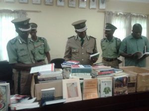 Commissioner of Prisons Percy Chato (centre) with some members of the Prisons Command. looking at the books donated from Canada