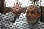 Egyptian Muslim Brotherhood leader Mohamed Badie waves from inside the defendants cage during the trial of Brotherhood members on February 3, 2014 near Cairo's Turah prison (AFP Photo/Ahmed Gamil)