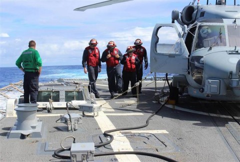 Sailors inspecting the flight deck of the Arleigh Burke-class destroyer USS Kidd (DDG 100) at sea in the Indian Ocean on March 16, while conducting search and rescue (SAR) operations for the missing Malaysian Airlines flight MH370