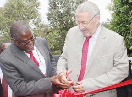 VICE President Guy Scott (right) is assisted to cut the ribbon by Minister of Mines, Energy and Water Development, Christopher Yaluma during the official opening of the Copperbelt Mining Trade Expo