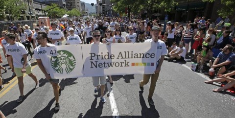 In this June 8, 2014, photo, workers carry a Starbucks banner during the gay pride parade, in Salt Lake City
