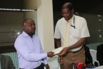 Handball Association of Zambia Communication Manager Josab Changa receiving a cheque fron Sport Council General Secretary Innocent Chabalesa
