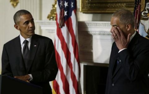 Attorney General Eric Holder wipes tears as President Barack Obama announces Holder's resignation in the White House State Dining Room, September 25, 2014