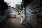 A member of the team enters the home of a victim – Ebola crisis in Liberia