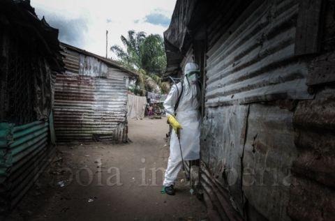A member of the team enters the home of a victim - Ebola crisis in Liberia