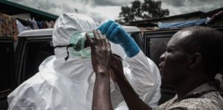 Adjusting a pair of protective goggles before the burial team sets off - Ebola crisis in Liberia