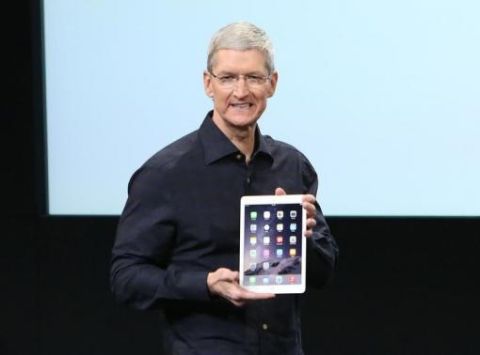 Apple CEO Tim Cook holds an iPad during a presentation at Apple headquarters in Cupertino, California October 16, 2014.