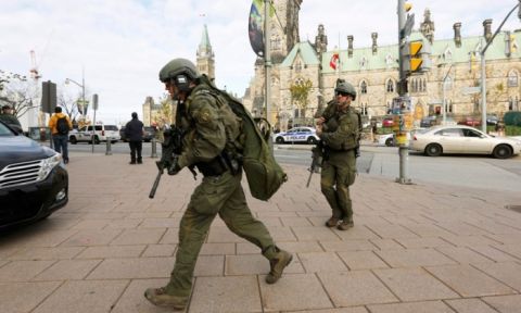 Armed RCMP officers head towards the Langevin Block on Parliament Hill. Photograph- Chris Wattie:Reuters