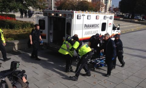 Police and paramedics transport a wounded soldier after a shooting at the war memorial. Photograph- Michael Comte:AFP:Getty