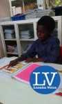 Kaunda Emmanuel Chikota takes his grandparents through his portfolio which was packed with activities and all materials of what he had been studying on a daily basis.  – Lusakavoice.com