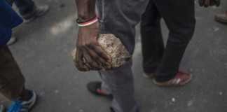 A man holds a brick near the hostels in the Jeppestown area of Johannesburg where clashes broke out(Mujahid Safodien:AFP)