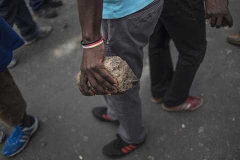 A man holds a brick near the hostels in the Jeppestown area of Johannesburg where clashes broke out(Mujahid Safodien:AFP)