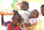 Girl carrying her baby sister on the her back. Her back is small enough for the baby to feel comfortable. This was in a village in Zambia.