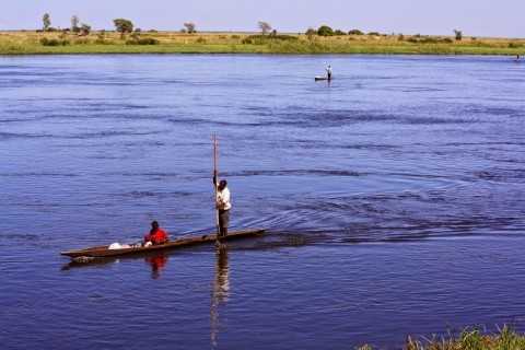 Here, a man paddles his wife and baby down the Zambezi River from, I assume, their village into the nearest town of Senanga. In the background are two other canoes making a similar trip.