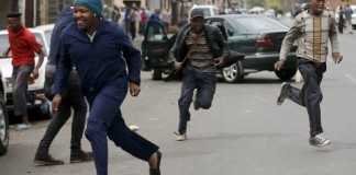 Locals run after trying to rob a foreign motorist in Johannesburg(Siphiwe Sibeko:Reuters)