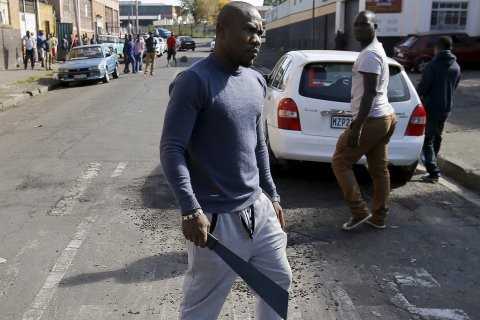 An African immigrant holds a machete in a run-down district of east Johannesburg(Siphiwe Sibeko/Reuters)