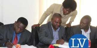 Buildcon CEO Moses Mubanga and RDA CEO Kanyuka Mumba - in a red tie- during the Chingola Solwezi Road construction Lot 2 contract signing ceremony at Mass Media area RDA offices