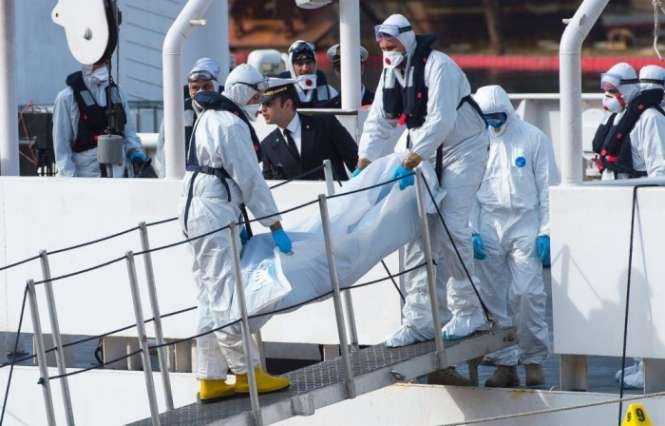 Men in protective gear disembark bodies for transport to the local morgue in Malta. Photograph- Ian Pace:Demotix:Corbis