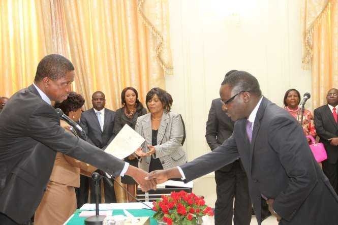 Zambia's Ambassador to France Humphrey Chibanda (r) being congratulated by President Edgar Lungu during the swearing -In-Ceremony at State House on May 4,2015 -Picture by THOMAS NSAMA