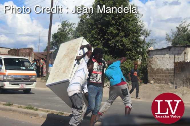 Some guys spotted along Matero- Lilanda carrying a fridge believed to have been looted. . - Lusakavoice.com